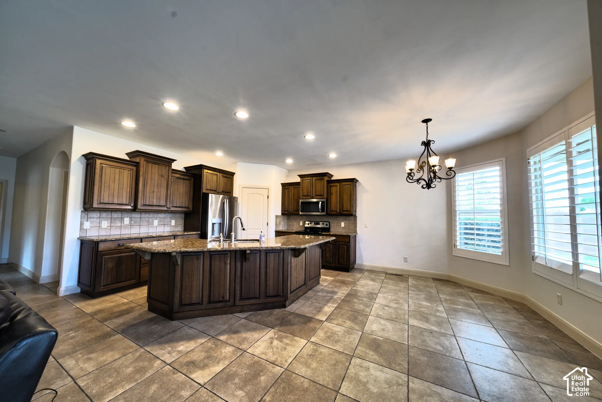 Kitchen with knotty alder cabinets, granite counters and a large island, open to the eating area.