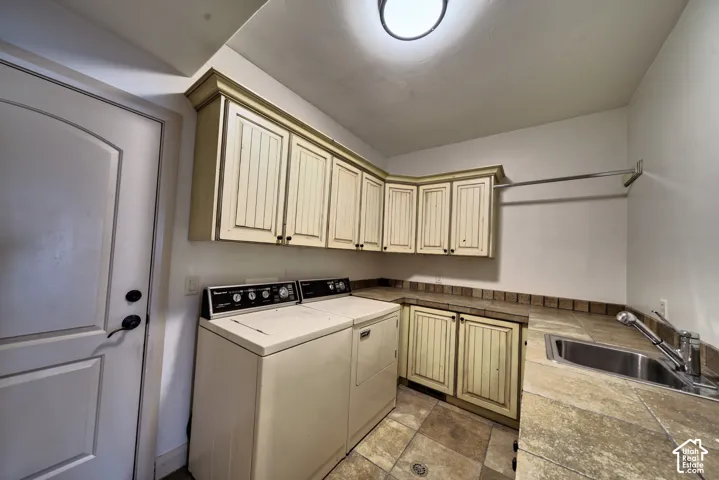 Laundry room with cabinets, a counter and a utility sink.