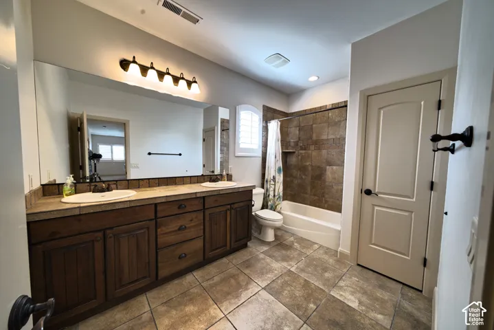 Upstairs full bathroom with two sinks and a tub and shower.