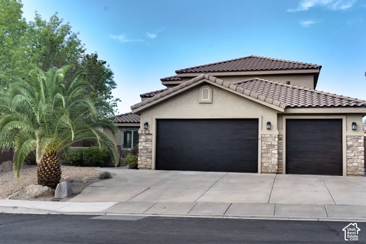 Front of the home: stucco and stone, tile roof and a 3-car garage.