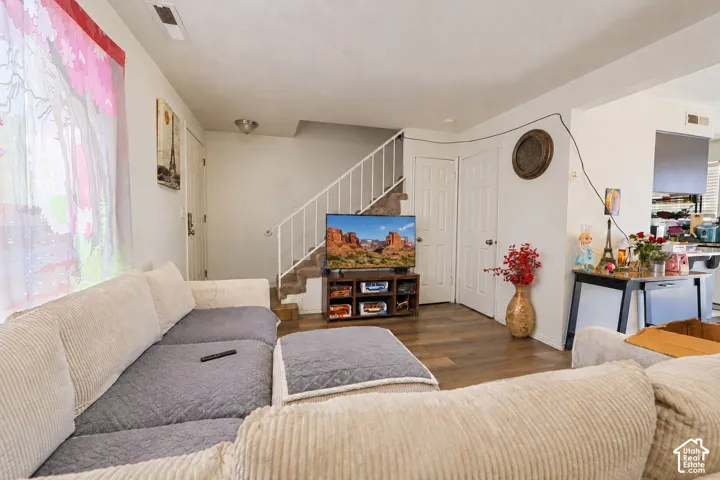 Wood-finish flooring, white metal staircase railing, and panel-style interior doors