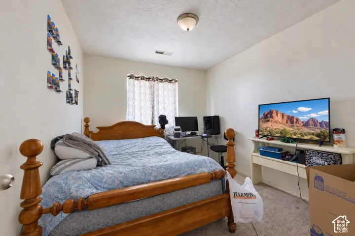 Neutral-toned room featuring wall-to-wall carpeting, a built-in shelving unit, and a single-pane window