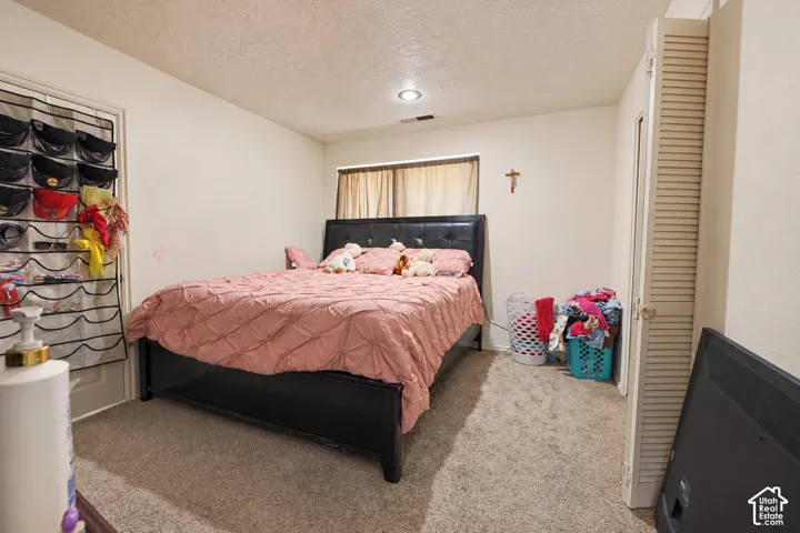 Neutral wall coloring, carpeting, recessed ceiling lighting, horizontal window, and folding closet doors