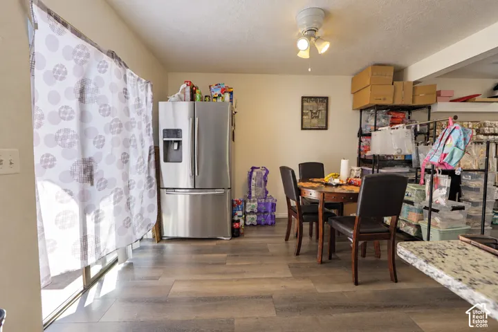 Stainless steel French-door refrigerator, wood-finish flooring, ceiling-mounted light fixture, and sliding glass door