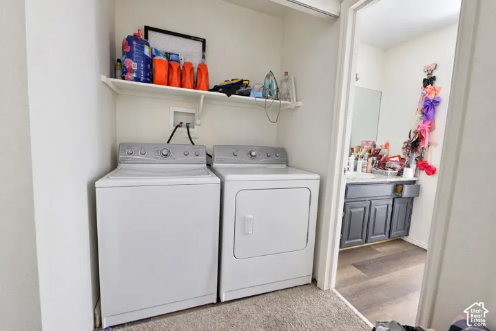 Laundry area featuring a built-in overhead storage shelf and carpeted flooring