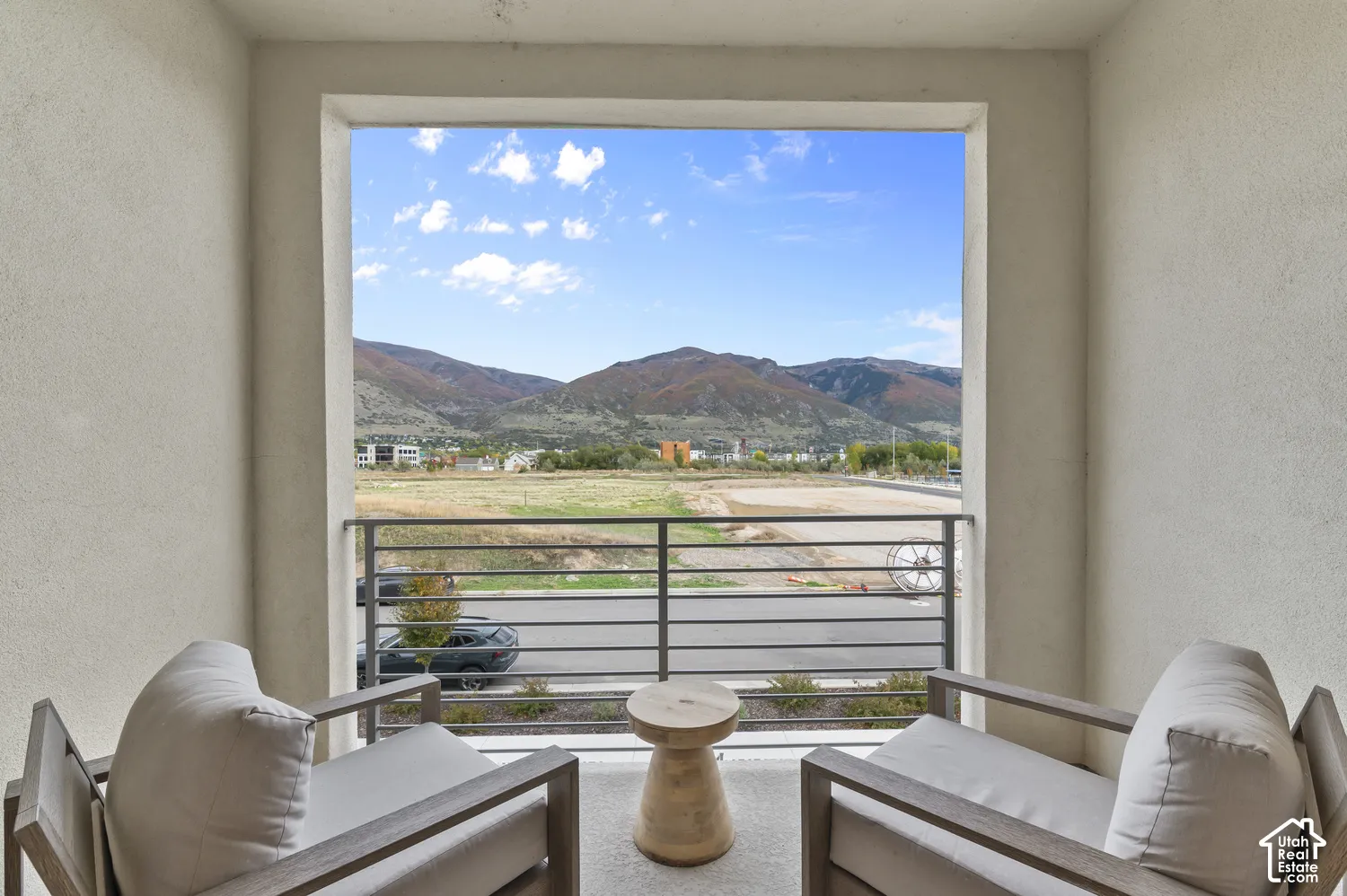 Covered balcony featuring horizontal metal railings and prominent mountain scenery