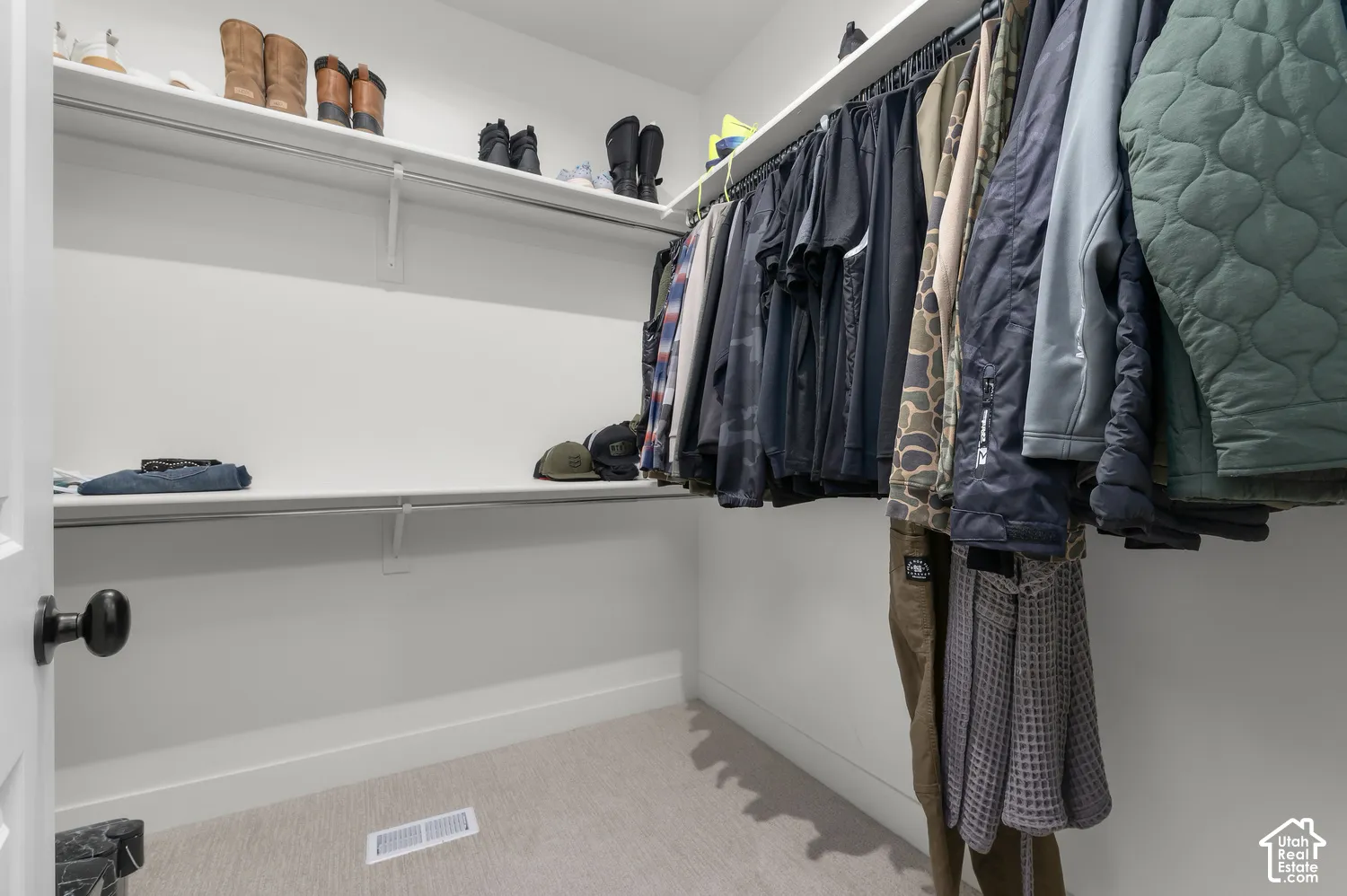 Walk-in closet featuring dual-tier shelving and integrated garment rods