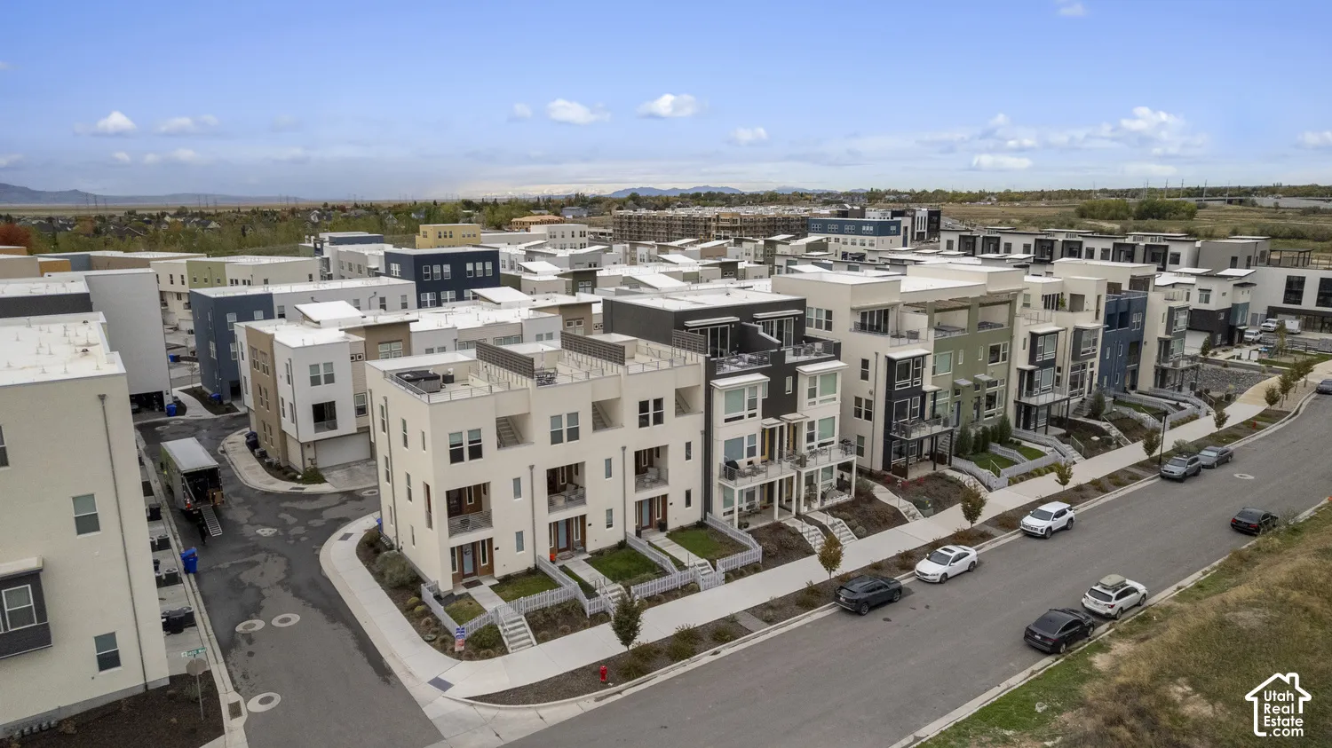 Multi-level townhome community featuring contemporary exterior architecture, integrated rooftop terraces, private balconies, and landscaped front entryways