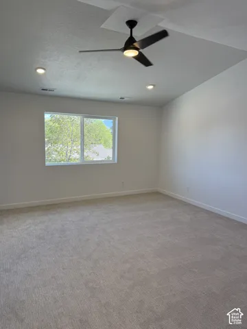 Vaulted ceilings featuring a black three-blade ceiling fan, recessed lighting, wall-to-wall carpeting, and a large single-pane window