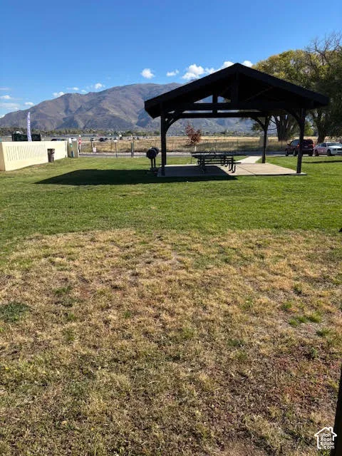 Outdoor space featuring a covered pavilion, concrete patio, and mountain backdrop