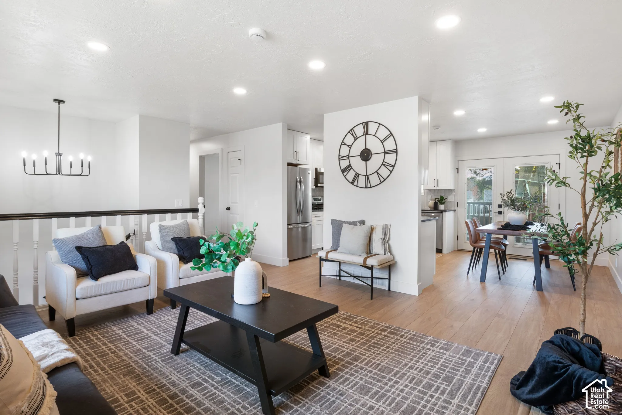 Open-concept area featuring recessed lighting, wood-finish flooring, a multi-arm chandelier, and glass-paned double doors