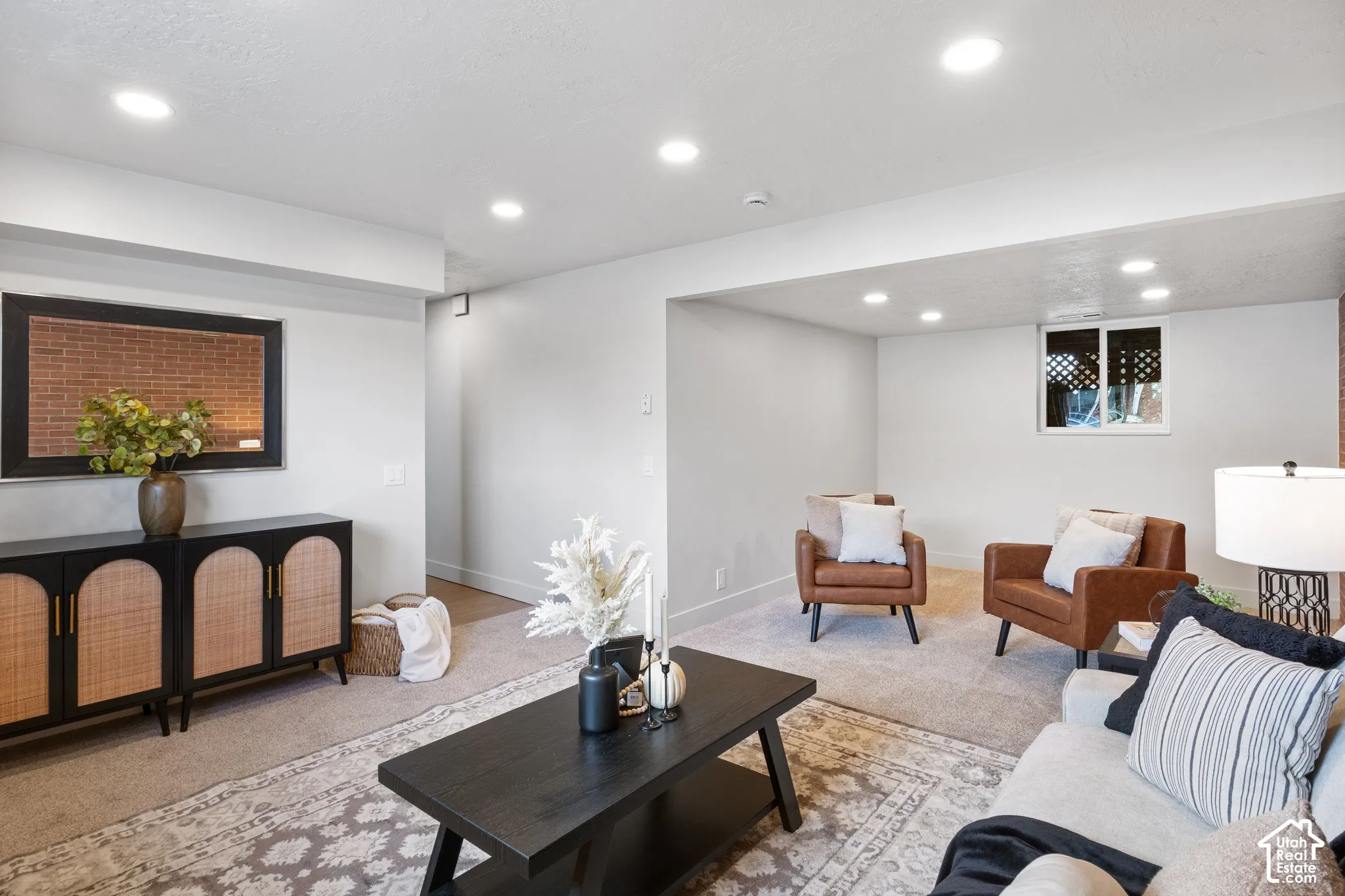 Interior space featuring recessed lighting, a horizontal window, wall-to-wall carpeting, and a recessed brick-accented wall section