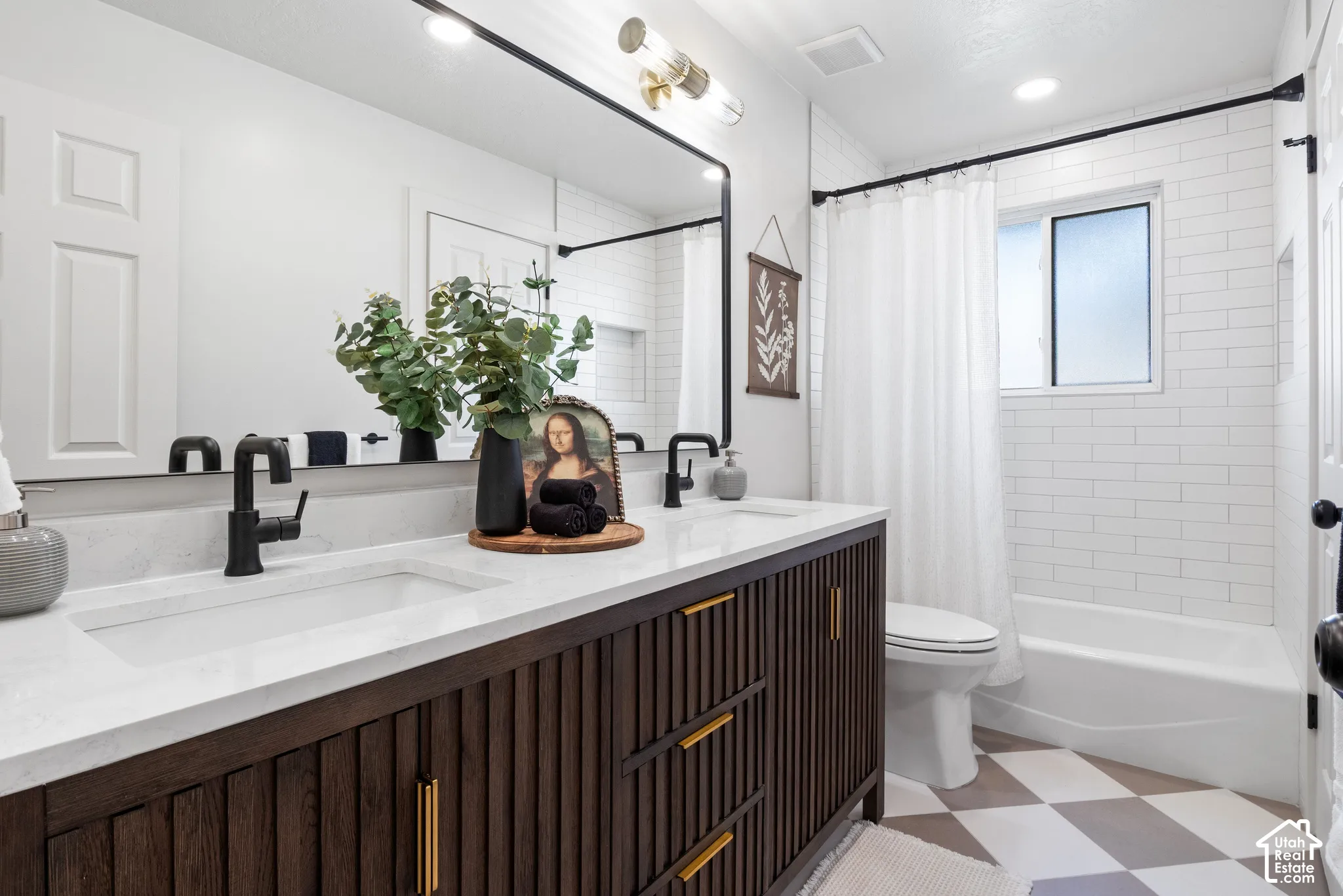 Double vanity featuring a slatted dark wood cabinet, white stone-finish countertop with integrated dual sinks, matte black faucets, and a full-width mirror with a black frame