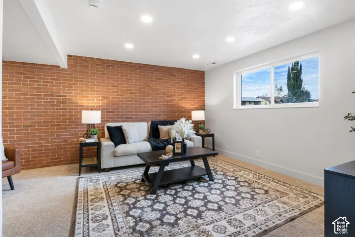 Exposed brick accent wall featuring recessed ceiling lighting and a large sliding window