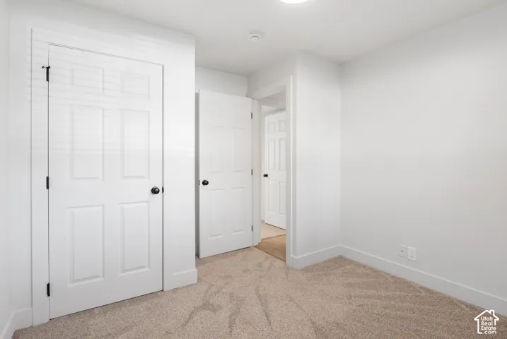 Neutral wall tones, wall-to-wall carpeting, and multiple six-panel interior doors with matte black hardware