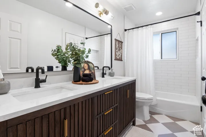 Double vanity featuring a slatted dark wood cabinet, white stone-finish countertop with integrated dual sinks, matte black faucets, and a full-width mirror with a black frame