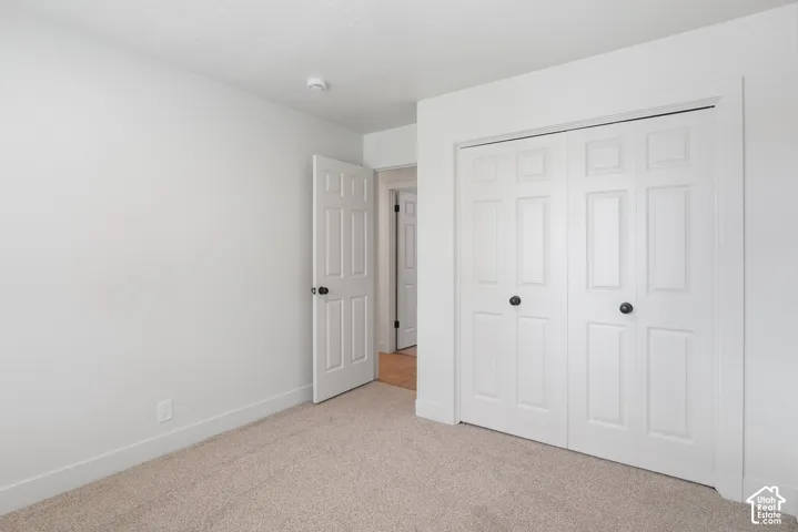Neutral wall coloring, wall-to-wall carpeting, six-panel interior doors, and a double-door closet with spherical hardware