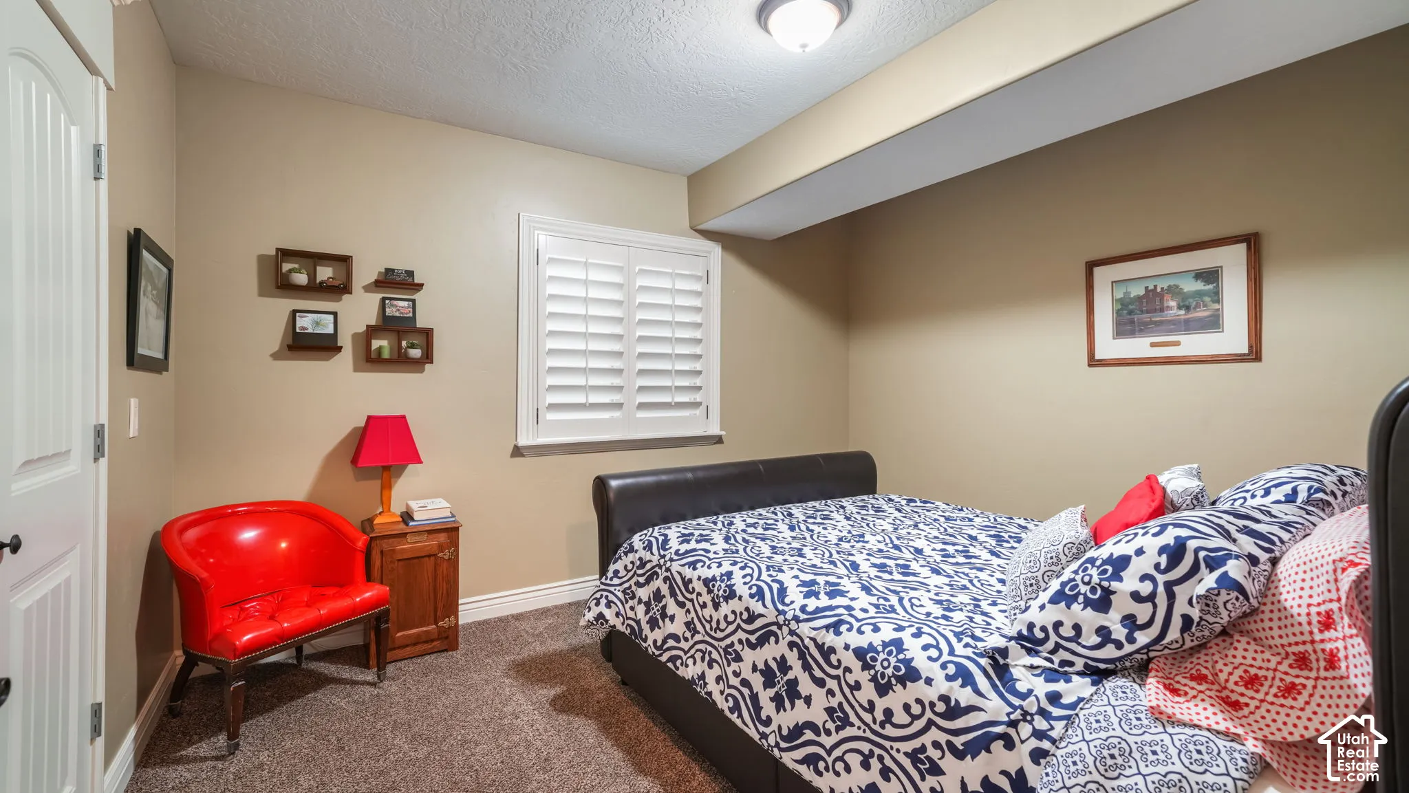 Neutral-toned room featuring plantation shutters, carpeted flooring, and a flush-mount ceiling light fixture