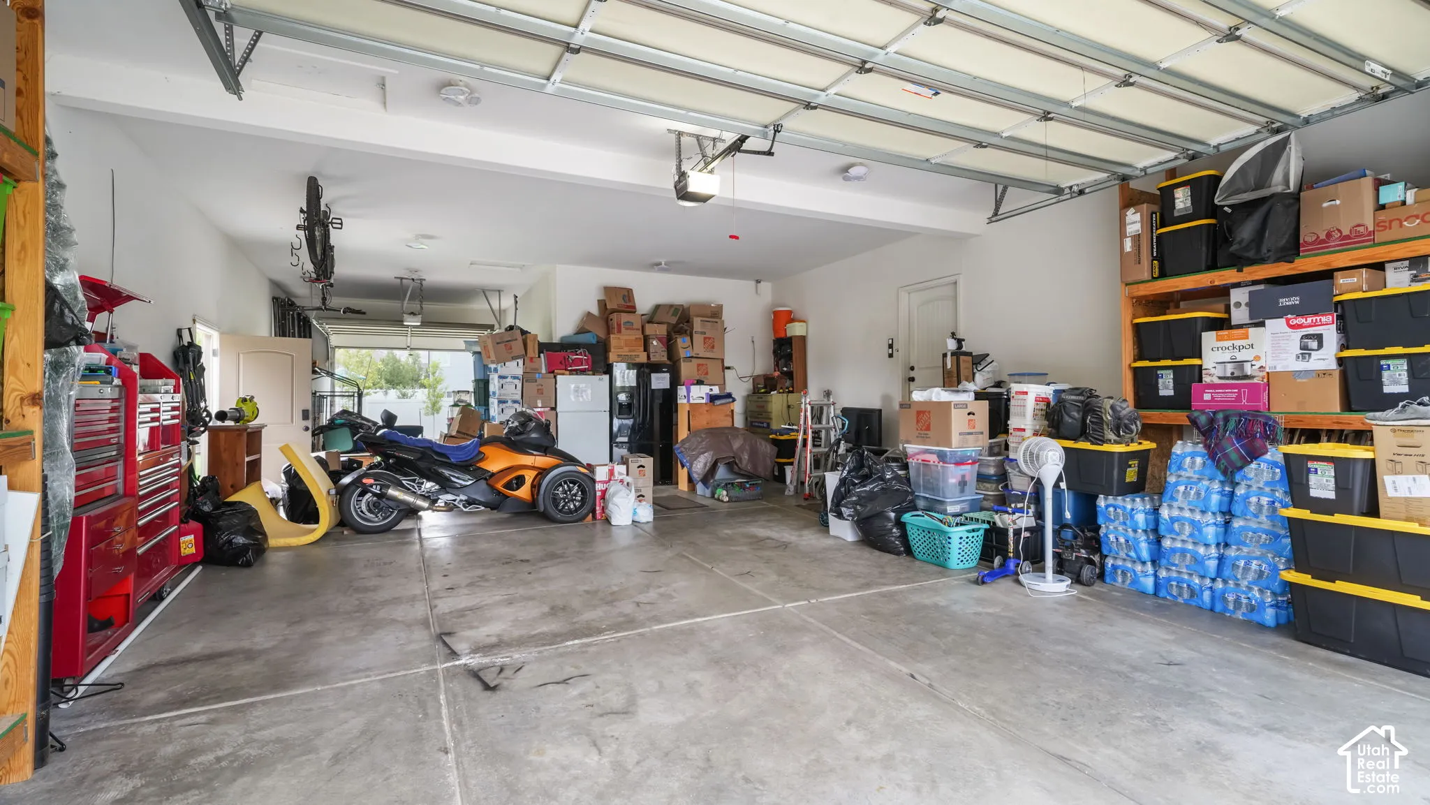 Multi-car garage featuring a concrete floor, automated overhead door, and direct exterior access door