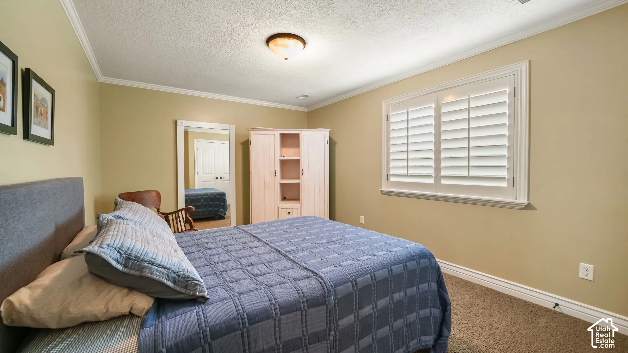 Neutral wall coloring, white plantation shutters, crown molding, and a central flush-mount light fixture