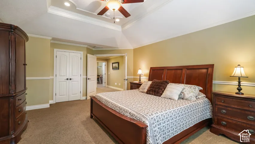 Tray ceiling with recessed lighting, central ceiling fan, and decorative chair rail molding