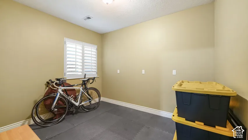 Room featuring white plantation shutters and neutral-toned wall paint