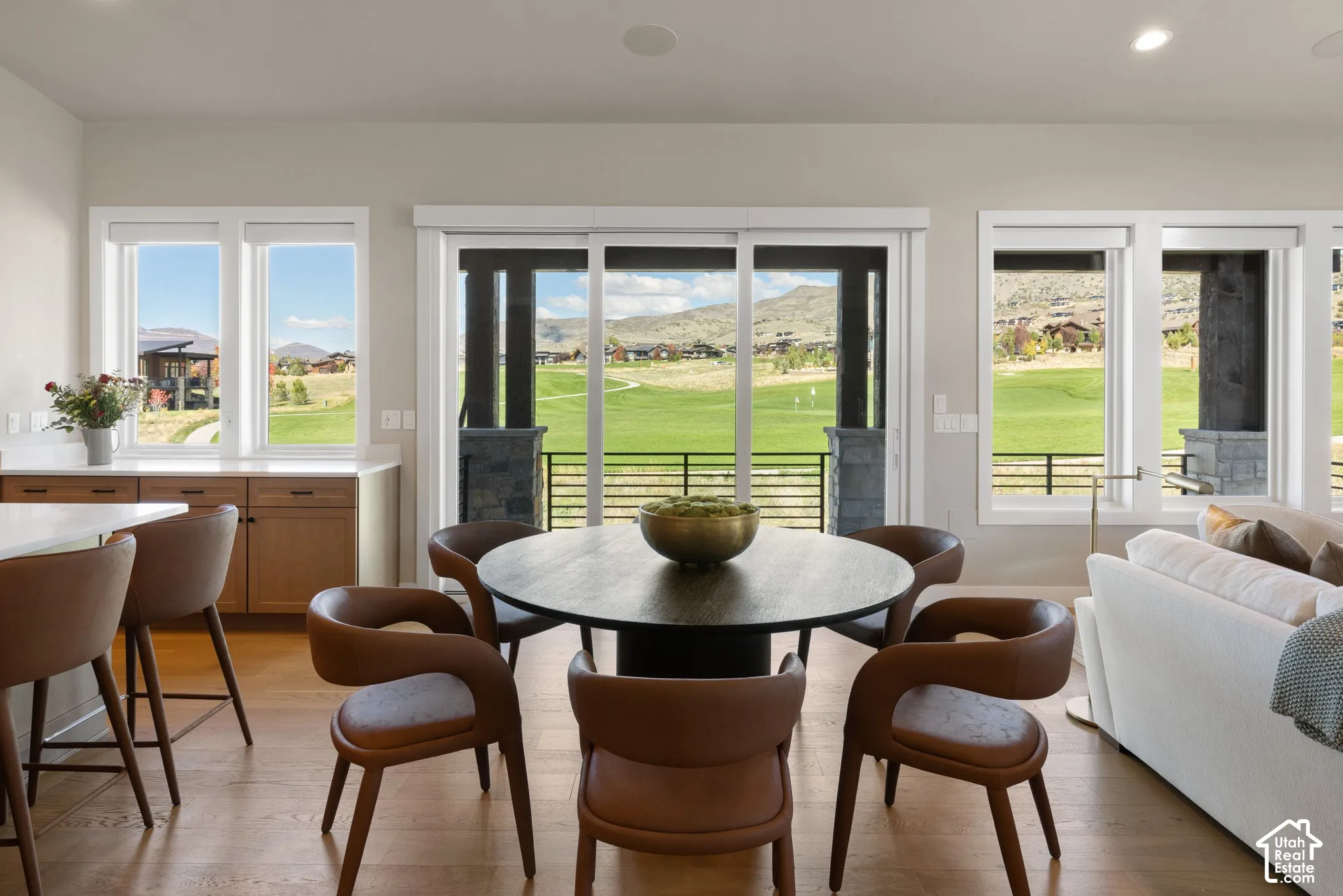 Wood-finish flooring, custom built-in cabinetry with stone-finish countertops, sliding glass doors with direct exterior access, and recessed ceiling lighting