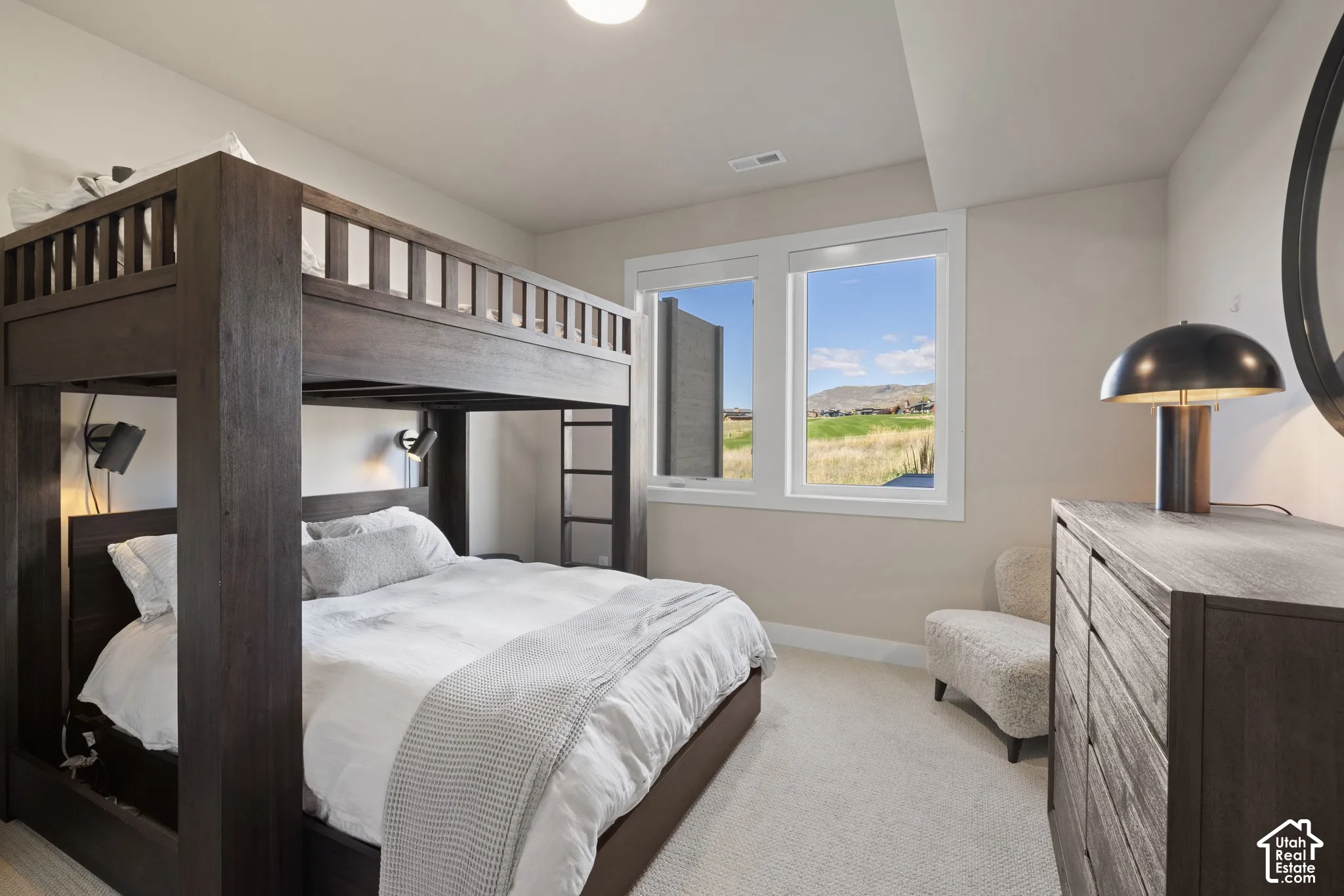 Neutral-toned interior space featuring wall-to-wall carpeting, dual-pane windows, and exterior scenery of mountainous terrain