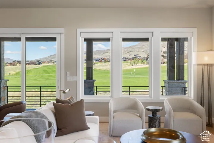 Large windows featuring white casing, expansive glass sliding doors, and mountain and golf course scenery
