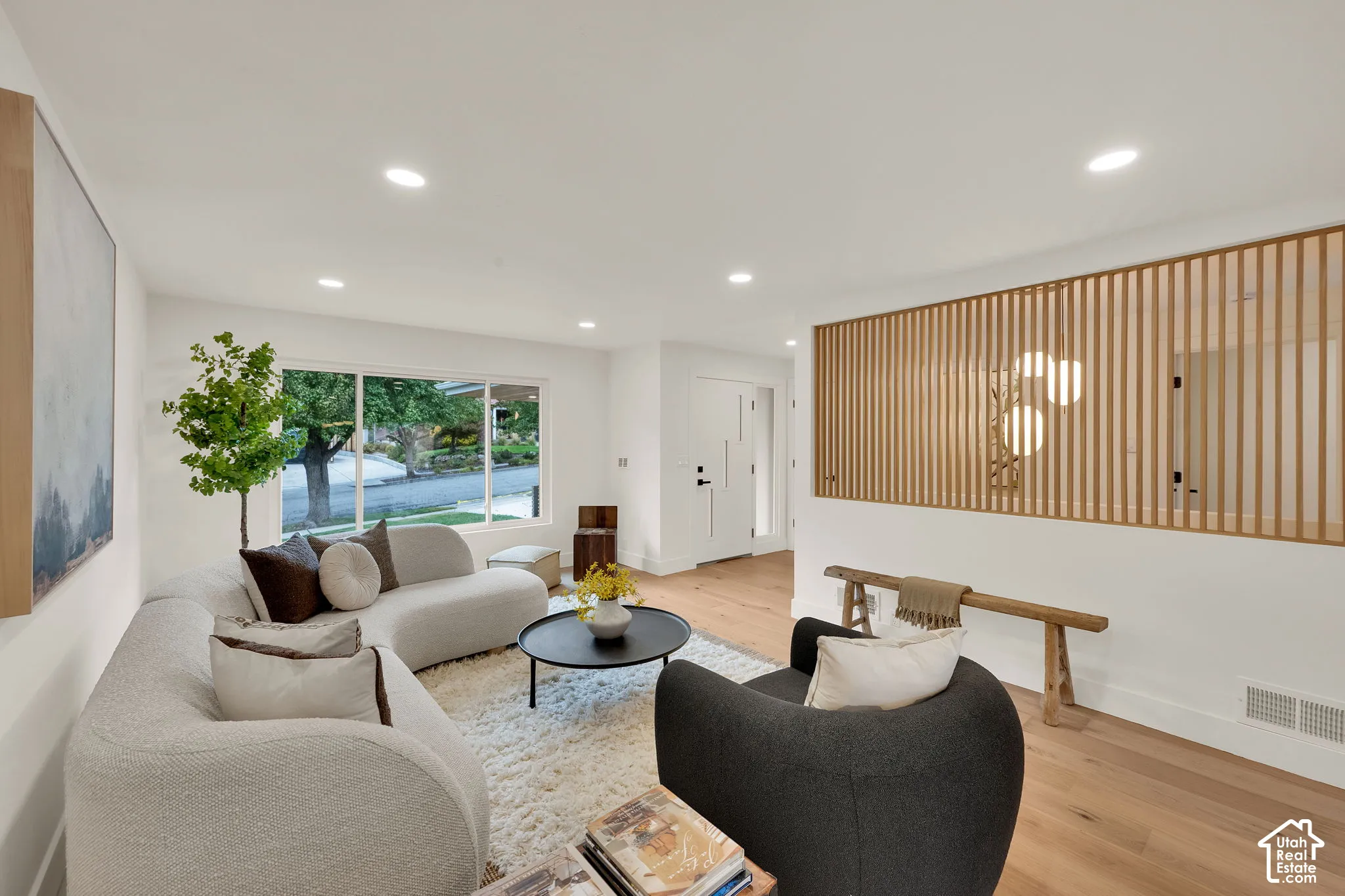 Open floor plan featuring recessed lighting, large picture window, and decorative slatted wood room divider