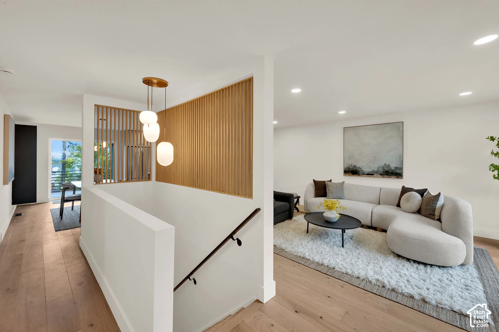Interior space featuring decorative slat wood wall paneling, a multi-pendant light fixture, and recessed lighting
