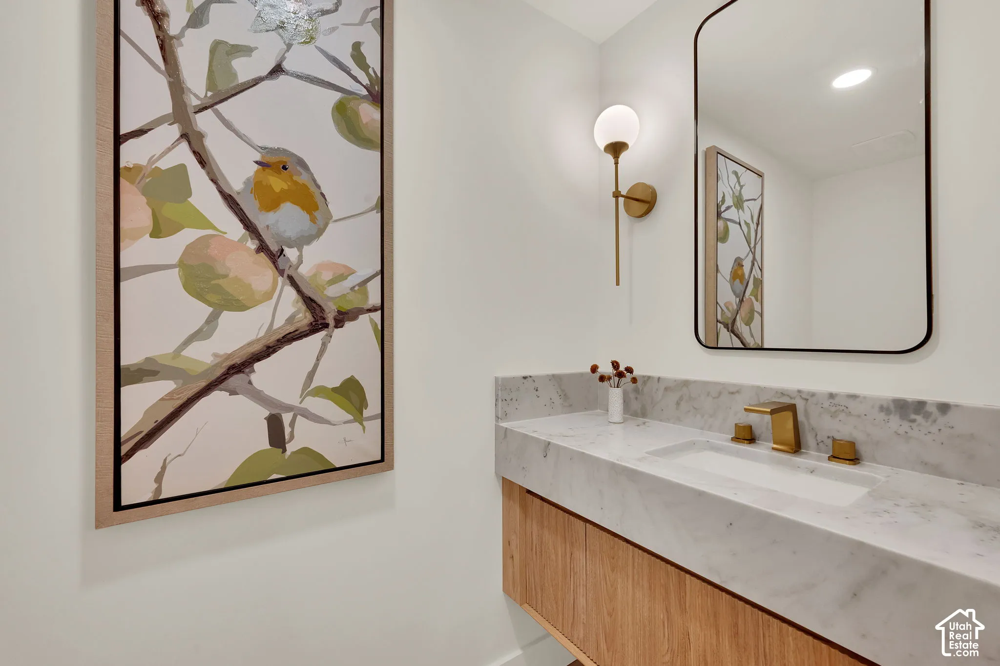 Guest bathroom. Floating wood-finish vanity with a stone countertop, & wall-mounted globe light fixture