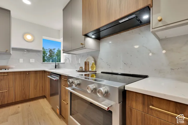 Kitchen featuring two-tone flat-panel cabinetry & stainless appliances