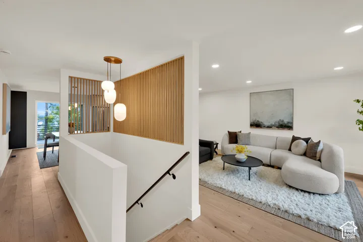 Interior space featuring decorative slat wood wall paneling, a multi-pendant light fixture, and recessed lighting