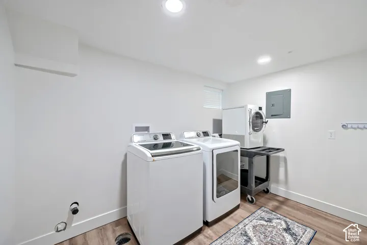 Utility area featuring wood-finish flooring, recessed lighting, and a wall-mounted electrical panel