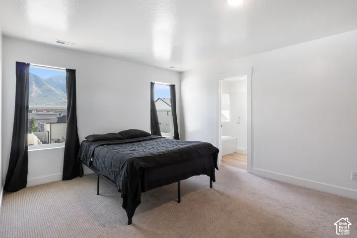 Neutral-toned carpeting, recessed ceiling lighting, and windows featuring mountain scenery