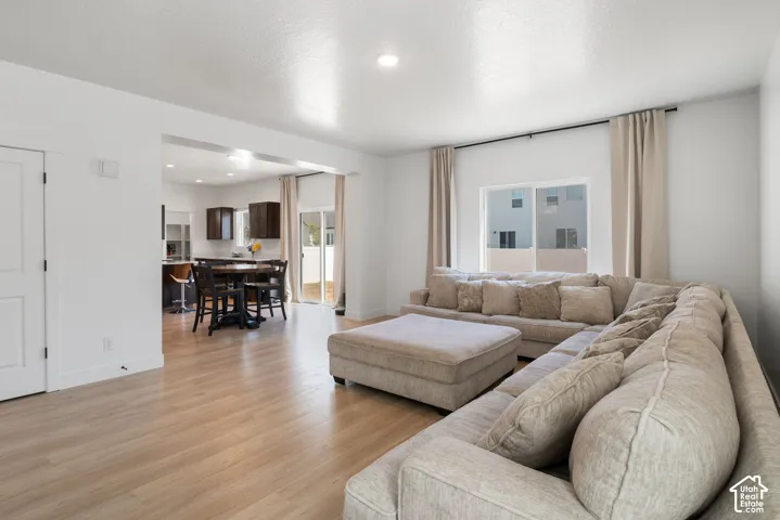 Open-concept living space featuring wood-finish flooring, recessed lighting, and large sliding glass doors