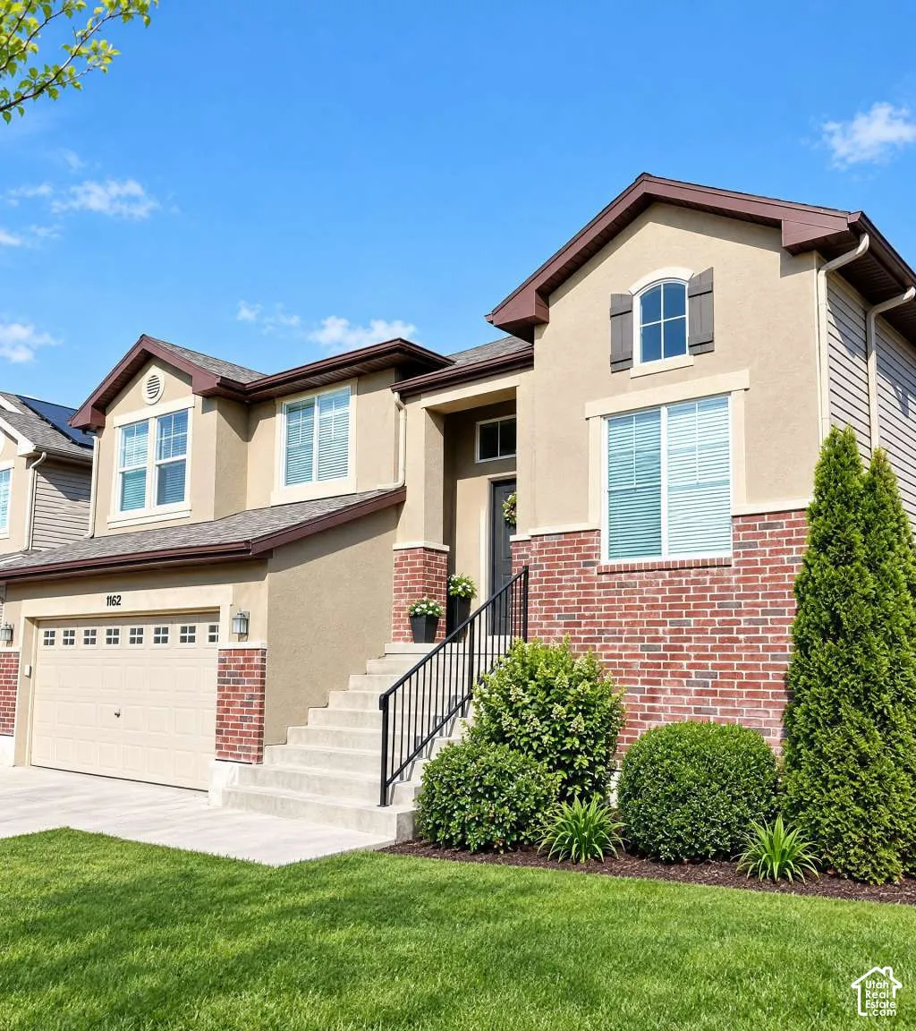 Multi-level exterior featuring stucco and brick facade, concrete staircase with iron handrail, multi-pane windows with shutters, and a multi-car garage