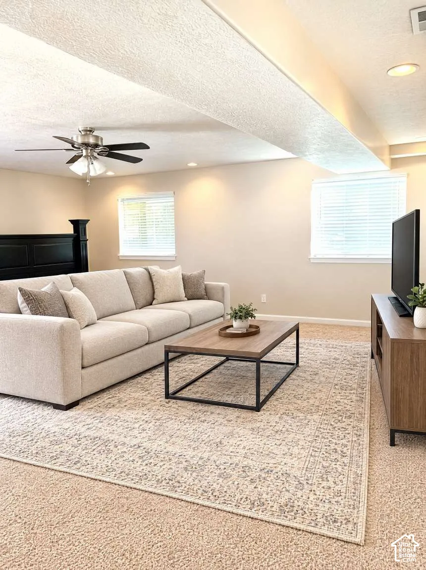 Neutral-toned interior space featuring recessed lighting, a brushed nickel ceiling fan, carpeted flooring, and dual windows with horizontal blinds