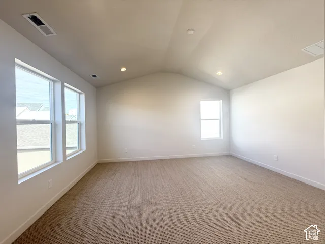 Vaulted ceilings featuring recessed lighting, neutral wall-to-wall carpeting, and large windows providing natural illumination