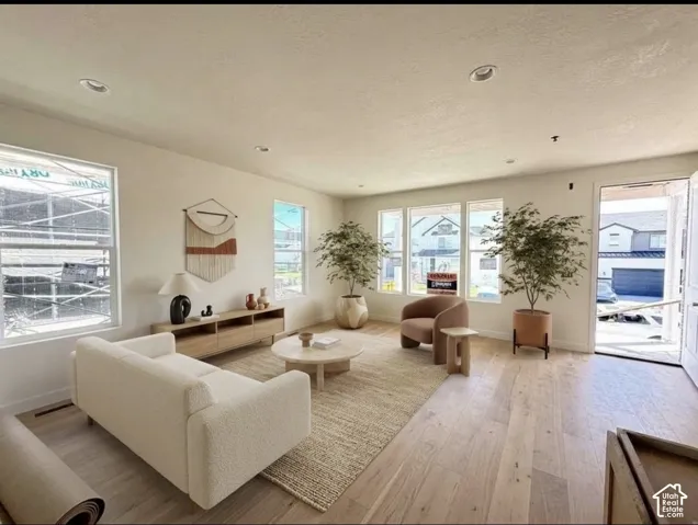 Living area featuring wood-finish flooring, recessed lighting, and multiple large windows