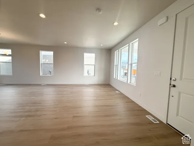 Open-concept space featuring wood-finish flooring, recessed lighting, and multiple windows providing natural light