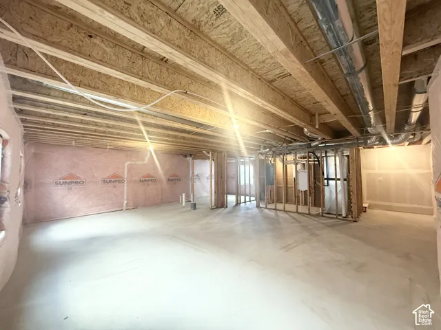 Unfinished interior space featuring exposed wood joists, concrete flooring, wall insulation, and exposed mechanical ductwork