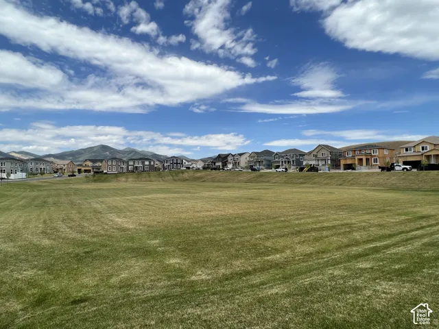 Expansive open space featuring a level grass lawn and mountain backdrop
