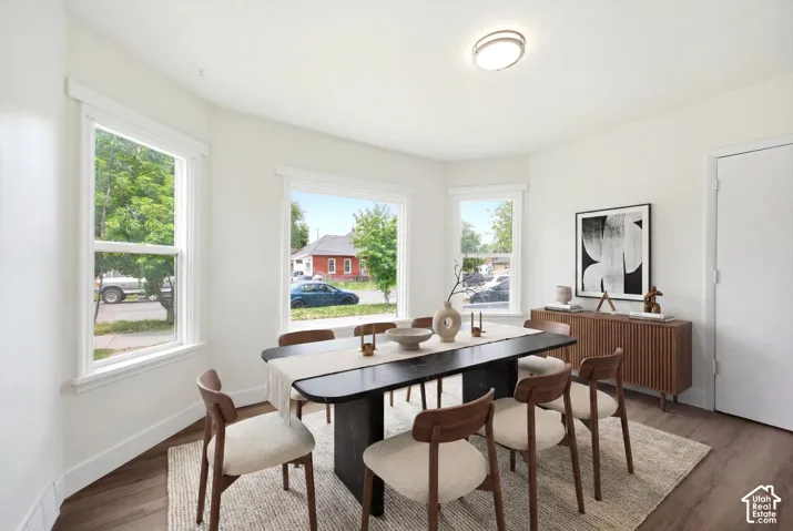 Interior space featuring wood-finish flooring, white walls, and triple window configuration with architectural trim