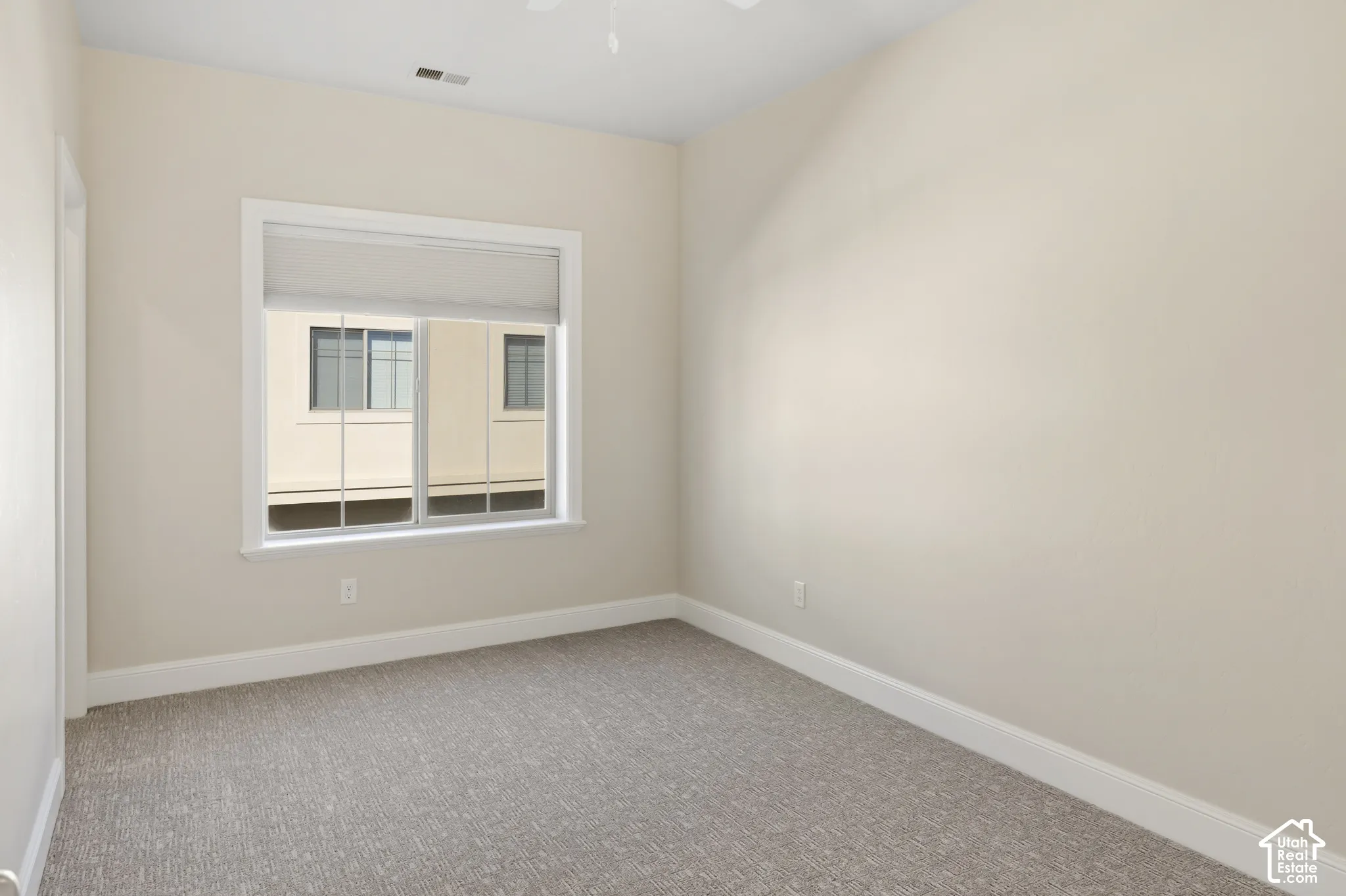 3rd Bedroom with a large walk-in closet featuring neutral wall paint, wall-to-wall carpeting, and a dual-pane sliding window with crisp white trim