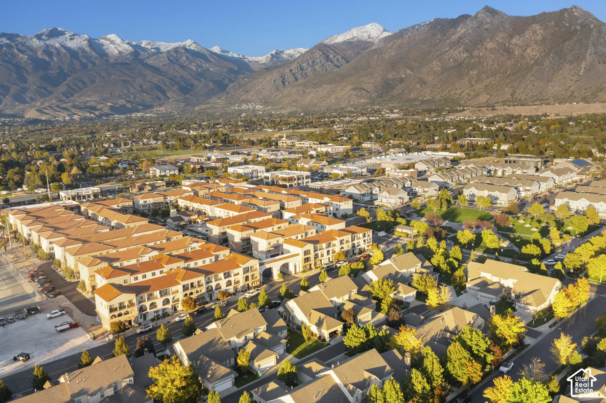 Aerial perspective featuring terracotta-tiled rooflines, expansive mountain backdrop, and mature landscaping