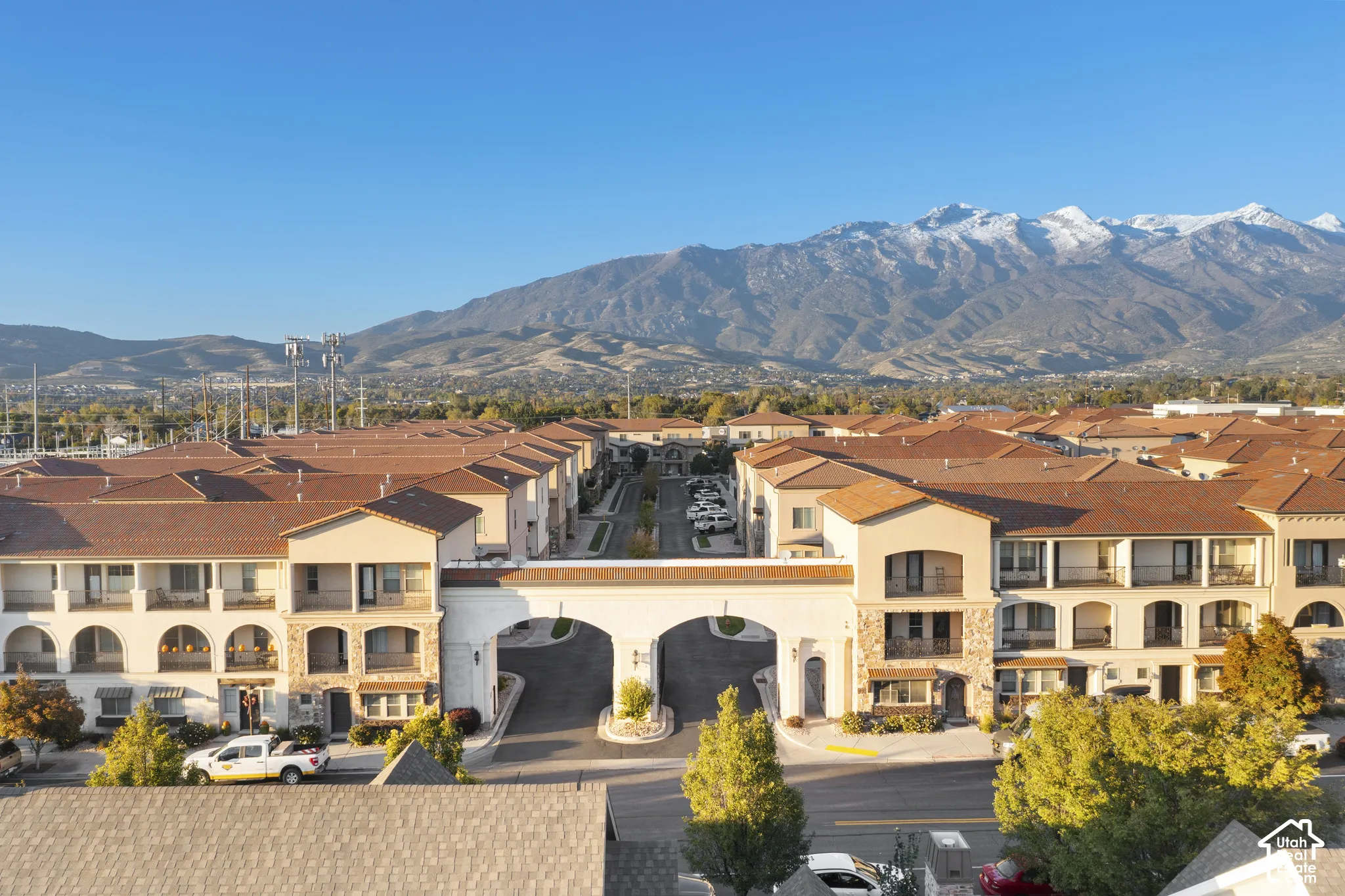 Aerial view featuring stucco exterior architecture, tiled rooflines, arched entryways, covered balconies, and mountain scenery