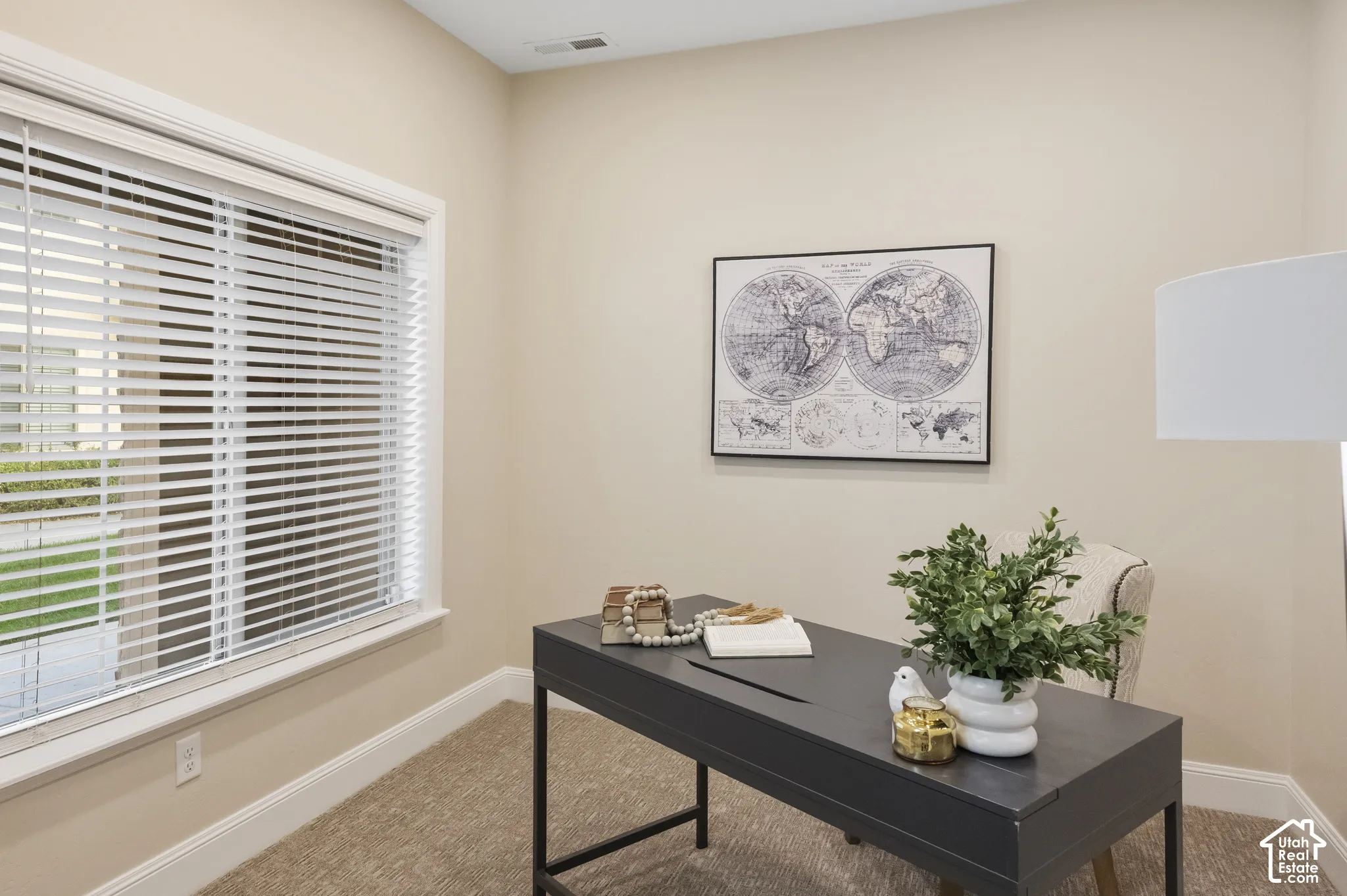 Home Office off the main entry with neutral-toned room featuring high-profile window casing, horizontal slat blinds, and wall-to-wall carpeting