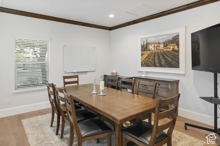 Boardroom featuring crown molding and wood-finish flooring